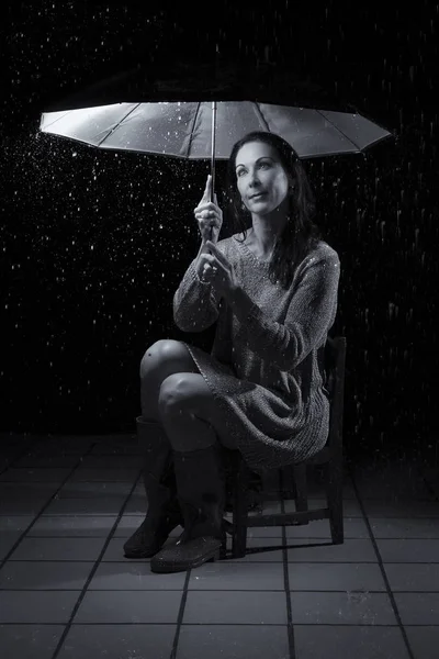 Piękna kobieta z srebrną suknię, siedząc pod parasolem w n — Zdjęcie stockowe