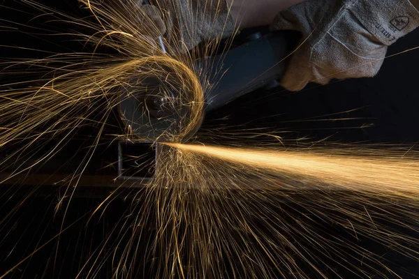 Winkelschleifer, der ein quadratisches Metallrohr schneidet, macht Funkenregen — Stockfoto