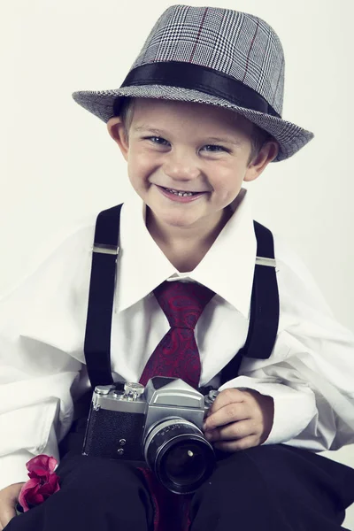 Молодий хлопець грає зі старою камерою, щоб бути фотографом — стокове фото