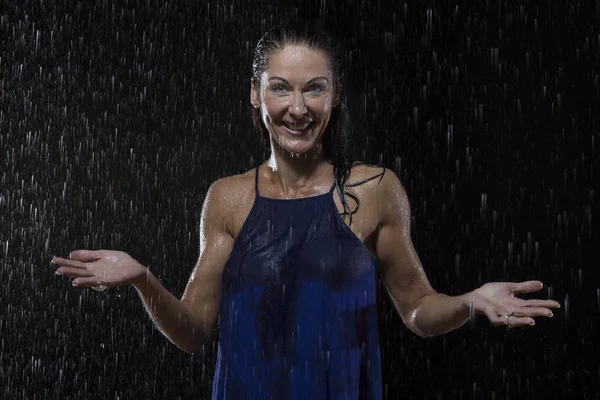 Schöne Frau in blauem Kleid steht nachts im Regen — Stockfoto