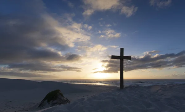 Ein altes Kreuz auf einer Sanddüne am Meer mit einem ruhigen Sonnenaufgang — Stockfoto