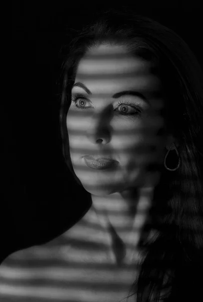 Portrait of a woman standing in darkness with shadow lines of bl — Stock Photo, Image