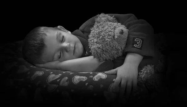 Funny boy with teddy bear on pillow before falling asleep artist — Stock Photo, Image