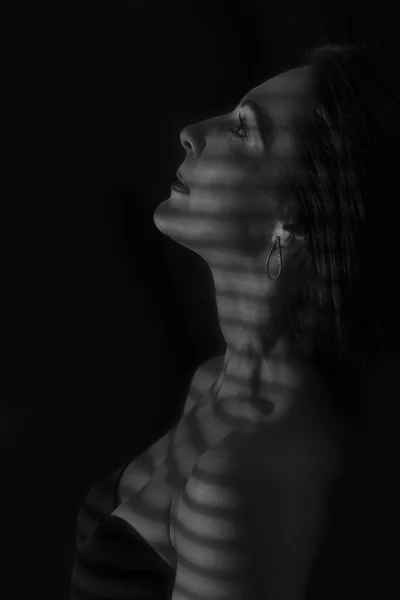 Portret kobiety pozowanie w ciemności z linii cienia blin — Zdjęcie stockowe