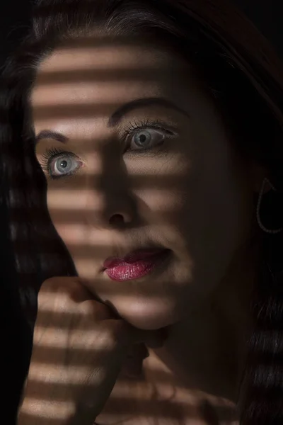 Portrét ženy stojící ve tmě s kontury stínů z bl — Stock fotografie