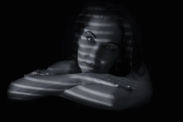 Retrato de una mujer de pie en la oscuridad con líneas de sombra de bl —  Fotos de Stock