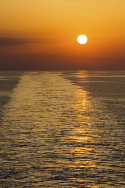 Landscape of a large boat wake on the ocean at sunset — Stock Photo, Image
