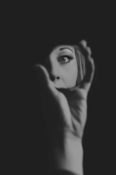 작은 거울 예술적 변환에 그녀의 눈을 보고 하는 여자 — 스톡 사진