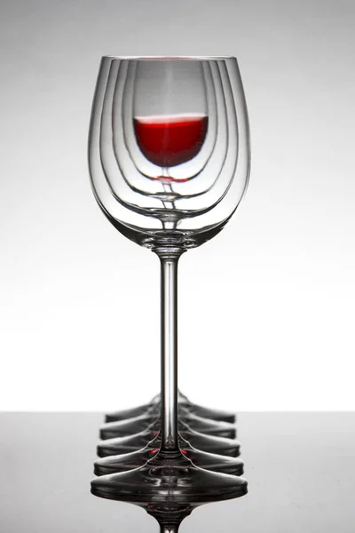 Row of empty wine glassesand one filled at the rear standing on — Stock Photo, Image