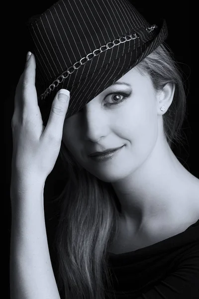 Porträtt närbild på en vacker blond kvinna med svart hatt arti Royaltyfria Stockfoton