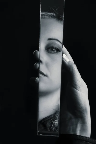 女人看着她的脸在破碎的镜子的碎片艺术 c — 图库照片