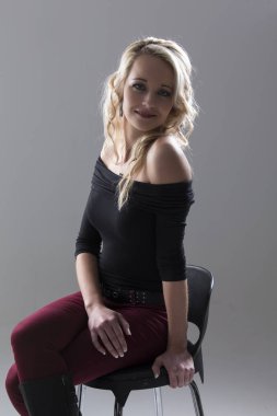 Güzel sarışın kadın kıvırcık saçlı ve siyah üst ve kırmızı pantolon 