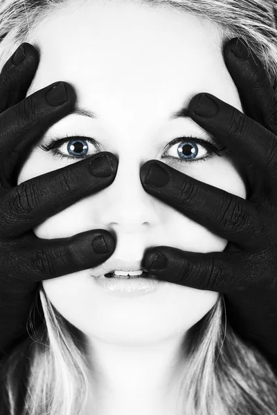 Frightened blonde woman grabbed by black hands on her face artis — Stock Photo, Image