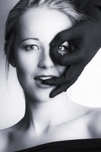 Mulher loira bonita olhando através de dedos de mão preta em — Fotografia de Stock