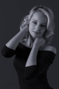 Güzel sarışın kadın kıvırcık saçlı ve siyah üstte gri backgr