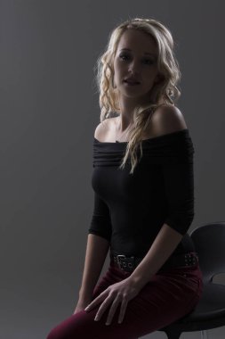 Güzel sarışın kadın kıvırcık saçlı ve siyah üst ve kırmızı pantolon 