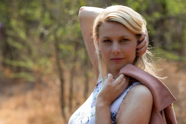 Portrait of a blonde woman outdoors walking along a trail in nat — Stock Photo, Image