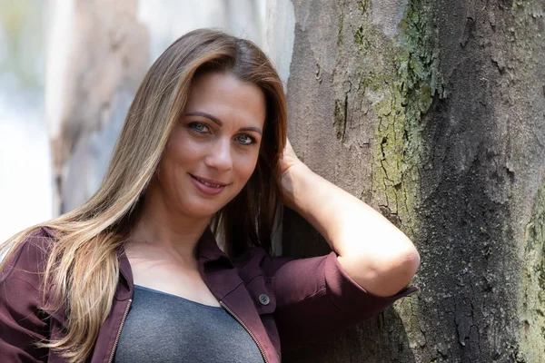 Portrait of a brunet woman with a blue denim and maroon jacket p — Stock Photo, Image