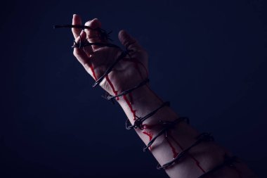 Stüdyonun sanatsal dönüşümünde dikenli telle bağlanmış bir el ve kolun konsept fotoğrafı