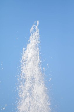 Mavi gökyüzüne karşı Su Çeşmesi sprey. Su sıçramaları odak dışında.