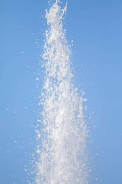 Mavi gökyüzüne karşı Su Çeşmesi sprey. Su sıçramaları odak dışında.