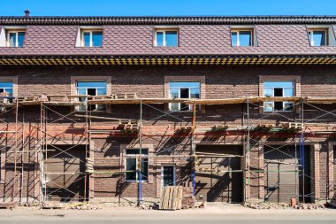 Tuğladan bir evin yüzü onarılıyor. İskeleli tuğla ev.