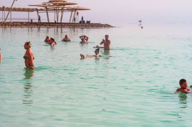 Dead Sea, Israel - 14 Kasım 2017: İsrail'de Ölü Deniz'in sularında yüzen kafkas adam. Plaj tatili.