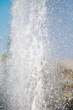 Mavi gökyüzüne karşı Su Çeşmesi sprey. Su sıçramaları odak dışında.