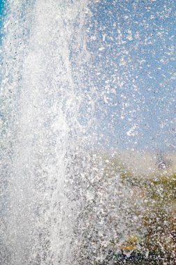 Mavi gökyüzüne karşı Su Çeşmesi sprey. Su sıçramaları odak dışında.