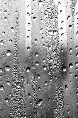 Cam üzerinde yağmur damlaları, siyah-beyaz arka plan, moda cam doku.