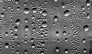 Cam üzerinde yağmur damlaları, siyah-beyaz arka plan, moda cam doku.