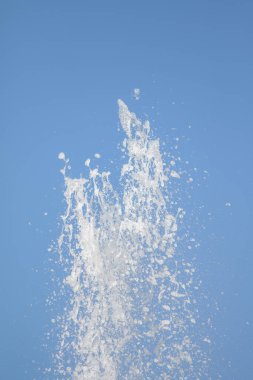 Mavi gökyüzüne karşı Su Çeşmesi sprey. Su sıçramaları odak dışında.