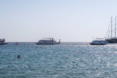 Şarm El-Şeyh, Mısır-11 Kasım 2017: Sharm El-Sheikh, Egypt 'te Naama Körfezi Denizi Plajı. İnsanlar yıkanmak, dinlenmek. Tekneler denizde yelken.