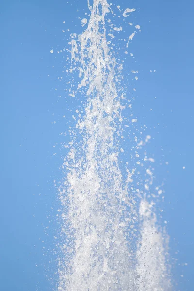 Mavi gökyüzüne karşı Su Çeşmesi sprey. Su sıçramaları odak dışında.