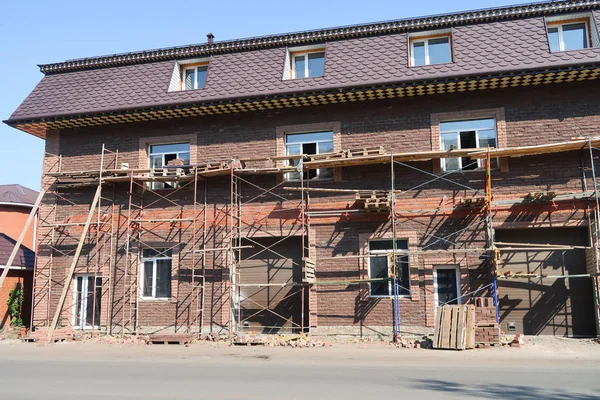 Tuğladan bir evin yüzü onarılıyor. İskeleli tuğla ev.