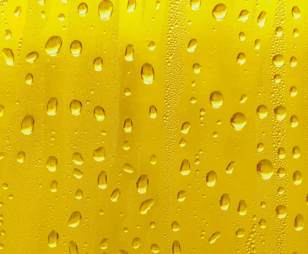 Cam su damlaları, sarı arka plan bira, buğulu arka plan.