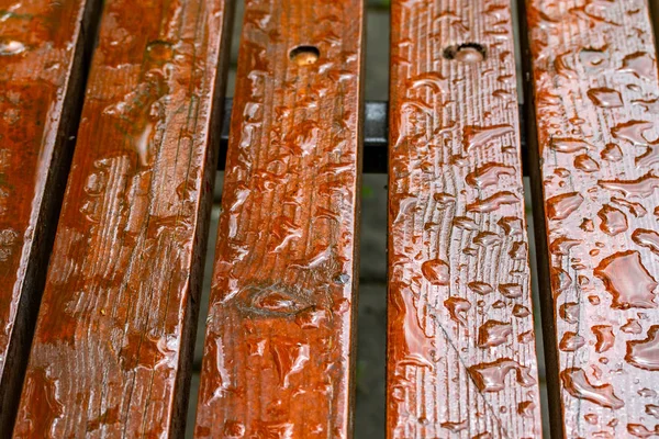 Tahta bir bankta yağmur damlaları. Yakın plan..