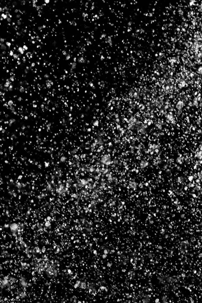 Su sıçramaları, beyaz bokeh, karanlık bir arka planda odak dışında bulanık arka plan.