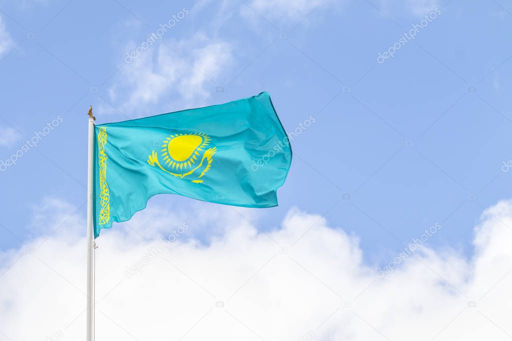 Flag of the Republic of Kazakhstan against the blue sky, wind.