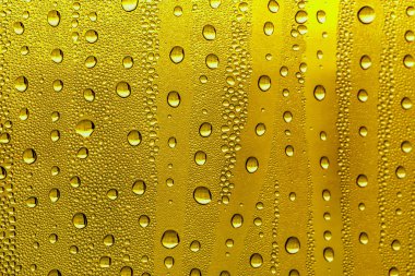 Cam su damlaları, sarı arka plan bira, buğulu arka plan.