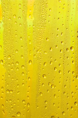 Cam su damlaları, sarı arka plan bira, buğulu arka plan.