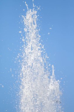 Mavi gökyüzüne karşı Su Çeşmesi sprey. Su sıçramaları odak dışında.