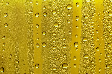 Cam su damlaları, sarı arka plan bira, buğulu arka plan.