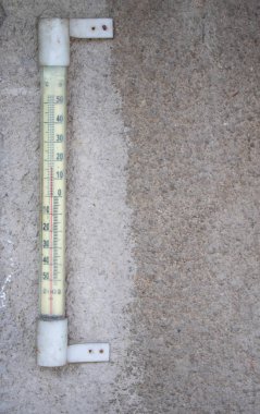 Sokakta duvara asılı cam termometre.