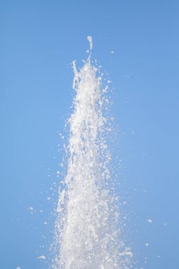 Mavi gökyüzüne karşı Su Çeşmesi sprey. Su sıçramaları odak dışında.