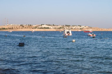 Şarm El-Şeyh, Mısır-11 Kasım 2017: Sharm El-Sheikh, Egypt 'te Naama Körfezi Denizi Plajı. İnsanlar yıkanmak, dinlenmek. Tekneler denizde yelken.