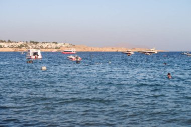Şarm El-Şeyh, Mısır-11 Kasım 2017: Sharm El-Sheikh, Egypt 'te Naama Körfezi Denizi Plajı. İnsanlar yıkanmak, dinlenmek. Tekneler denizde yelken.