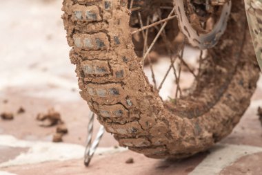 Çamurda motosiklet tekerleği. Sokakta yakın plan..