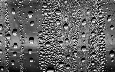 Cam üzerinde yağmur damlaları, siyah-beyaz arka plan, moda cam doku.