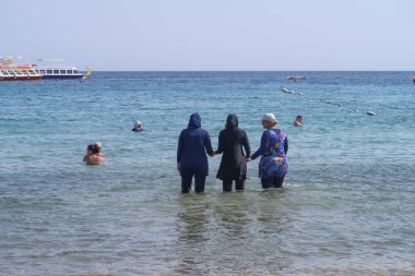 Şarm El-Şeyh, Mısır-11 Kasım 2017: Sharm El-Sheikh, Egypt 'te Naama Körfezi Denizi Plajı. İnsanlar yıkanmak, dinlenmek. Tekneler denizde yelken.